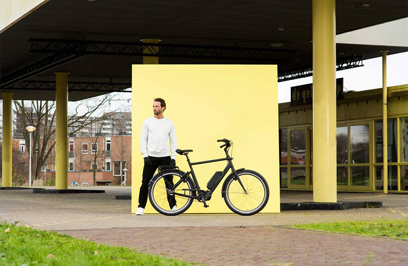 Man naast Union E-Lite fiets voor geel bord